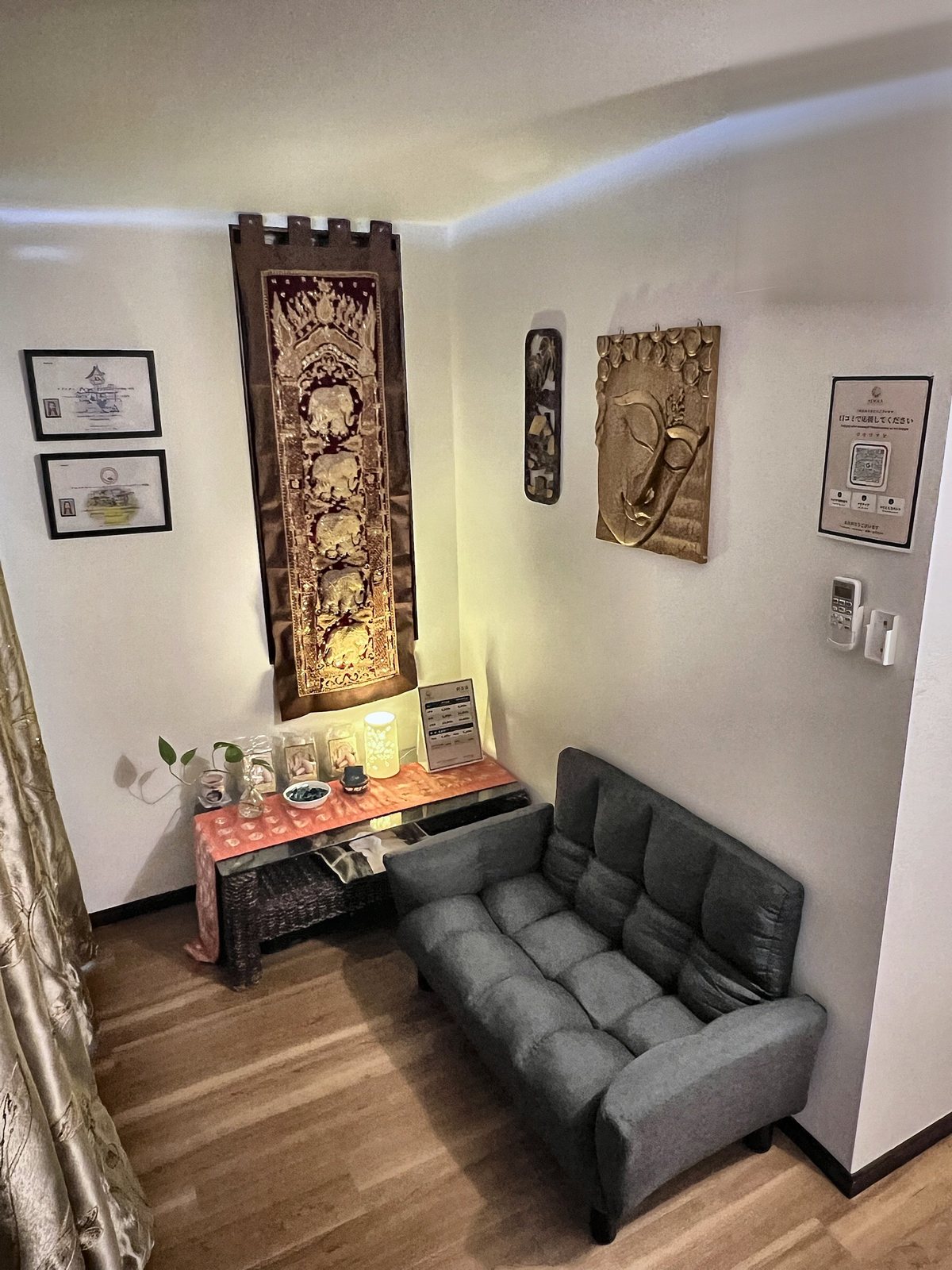 Waiting area with sofa, Thai elephant tapestry and golden Buddha relief