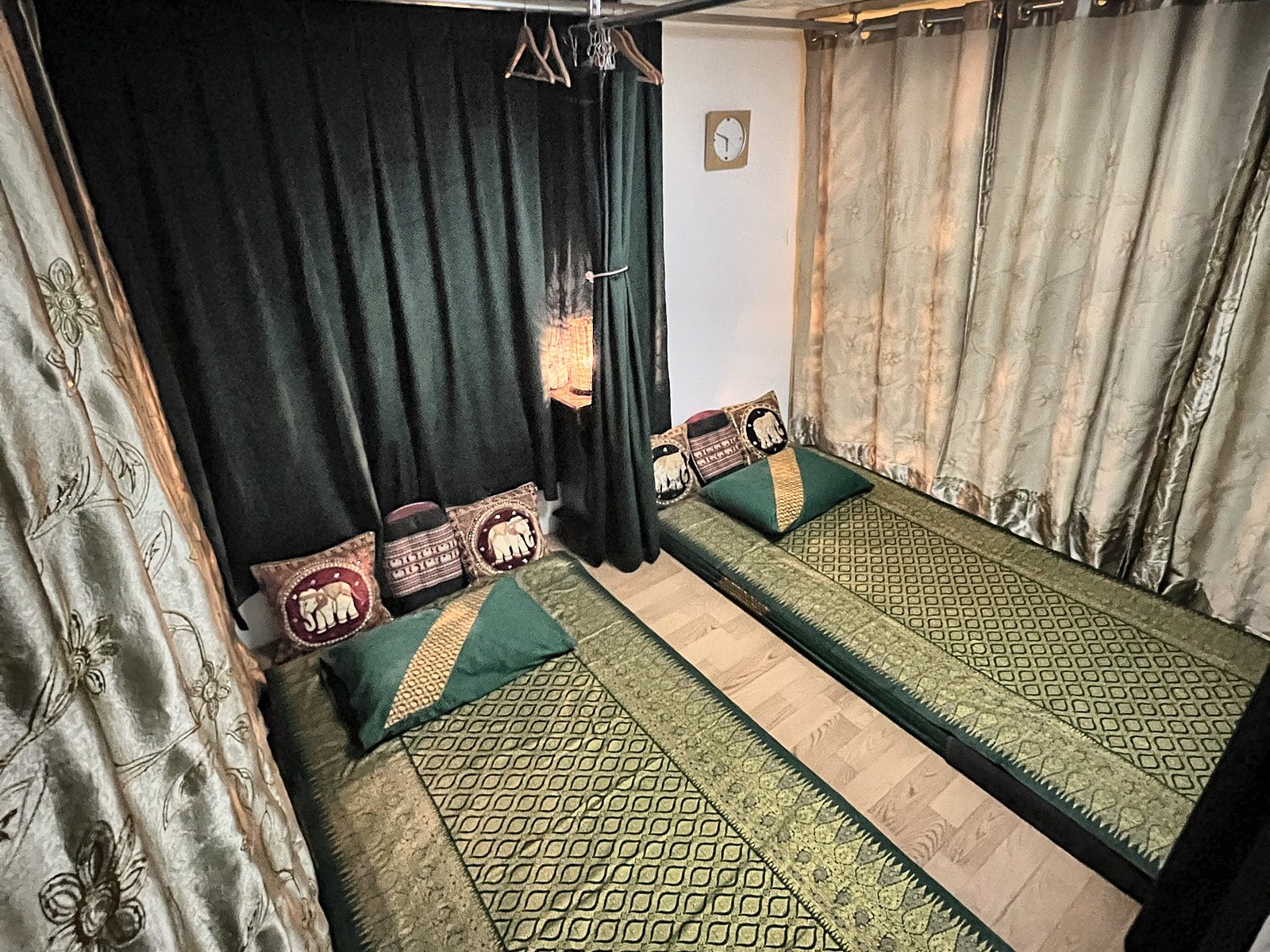 Two Thai massage mats with elephant cushions and lantern light